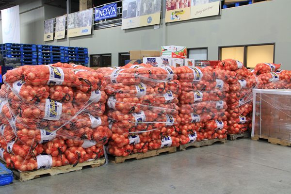 Onions are moved in the Community Food Share warehouse.