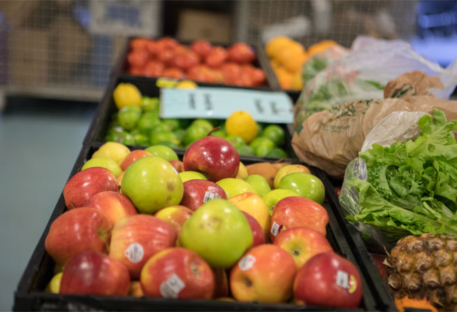 A selection of fresh produce. Red apples, green apples, and a pineapple are visible.