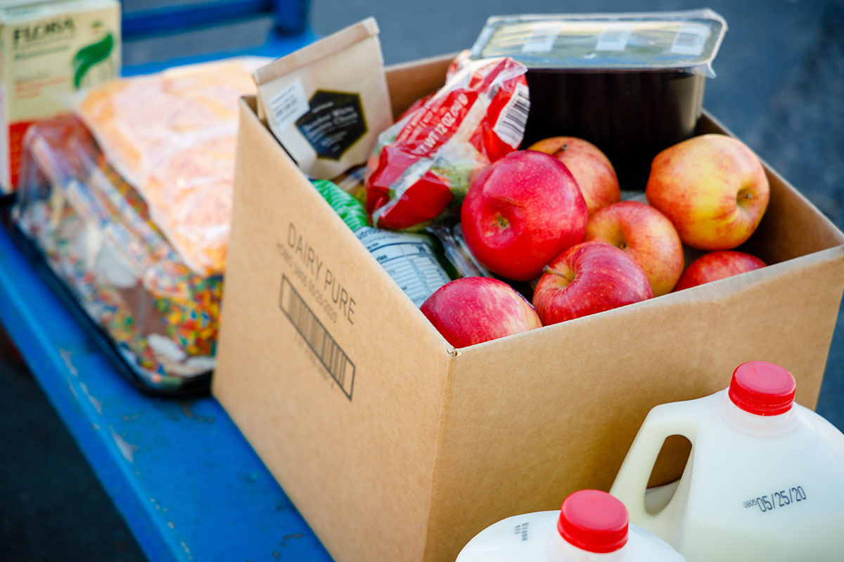 A cart full of healthy foods such as apples and milk