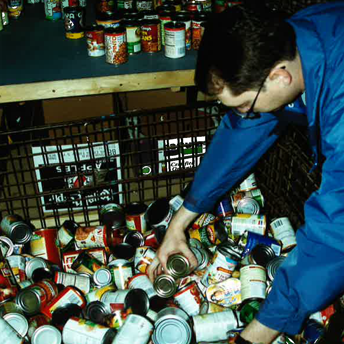 A man sorts through canned goods after a food drive