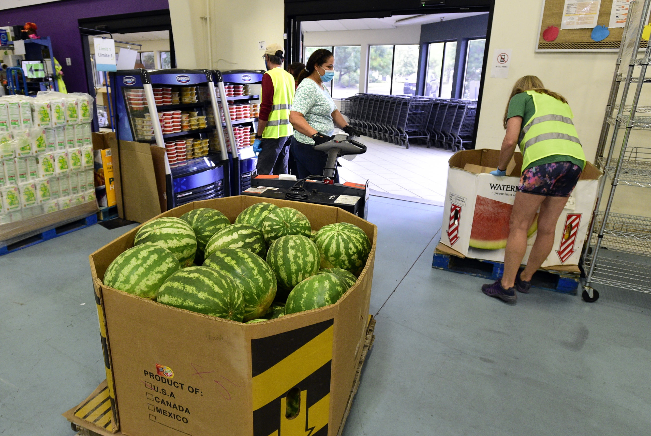 A carton of watermelons sits in the middle of the food pantry floor